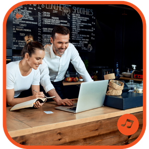 Staff using a laptop to select a playlist from the background sounds royalty-free music library
